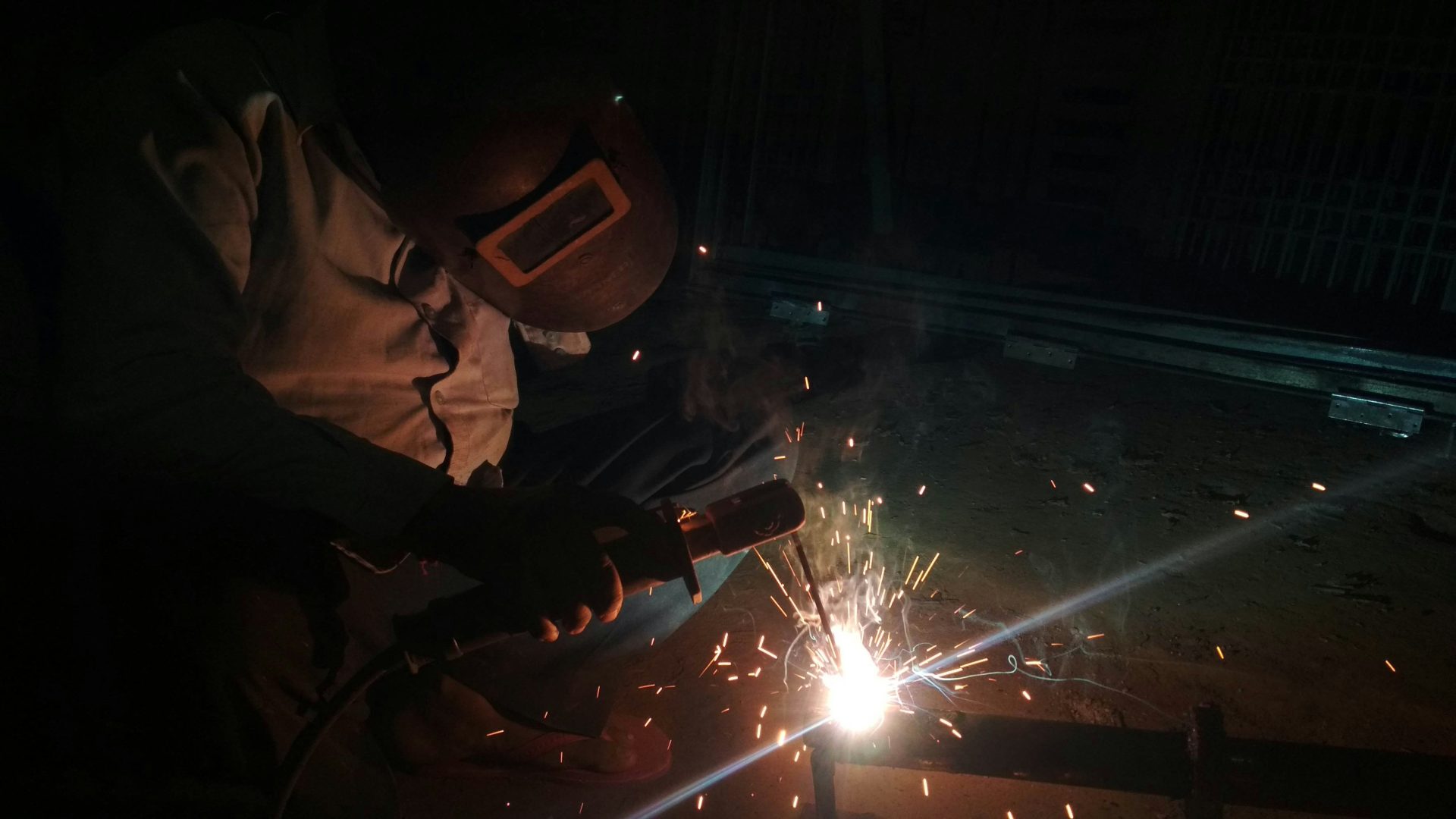 Ein Mann schweißt im Dunkeln ein Stück Metall.